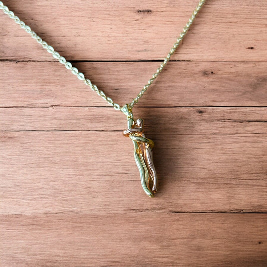 Lovely stainless steel necklace of couple figure silhouettes dancing in gold/rose gold.