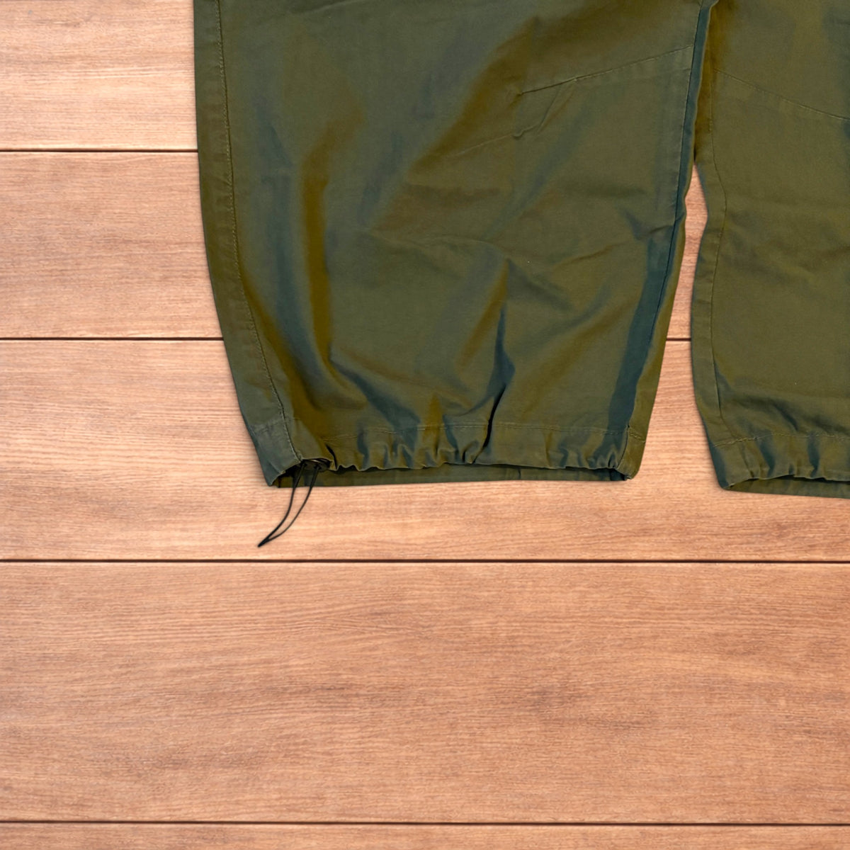 Baggy wide leg ripstop cargo trousers in khaki green with pockets, elasticated waist, and toggled hems.