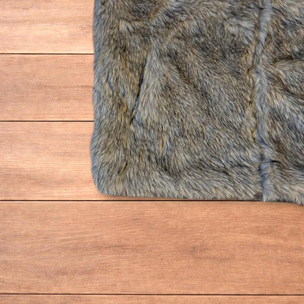 Beige brown faux fur gilet jacket with full zip on wooden surface