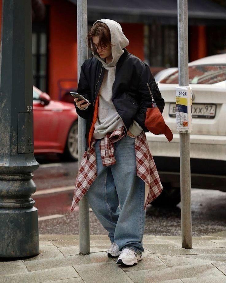 Layered streetwear outfit with hoodie, bomber jacket, shirt and baggy jeans