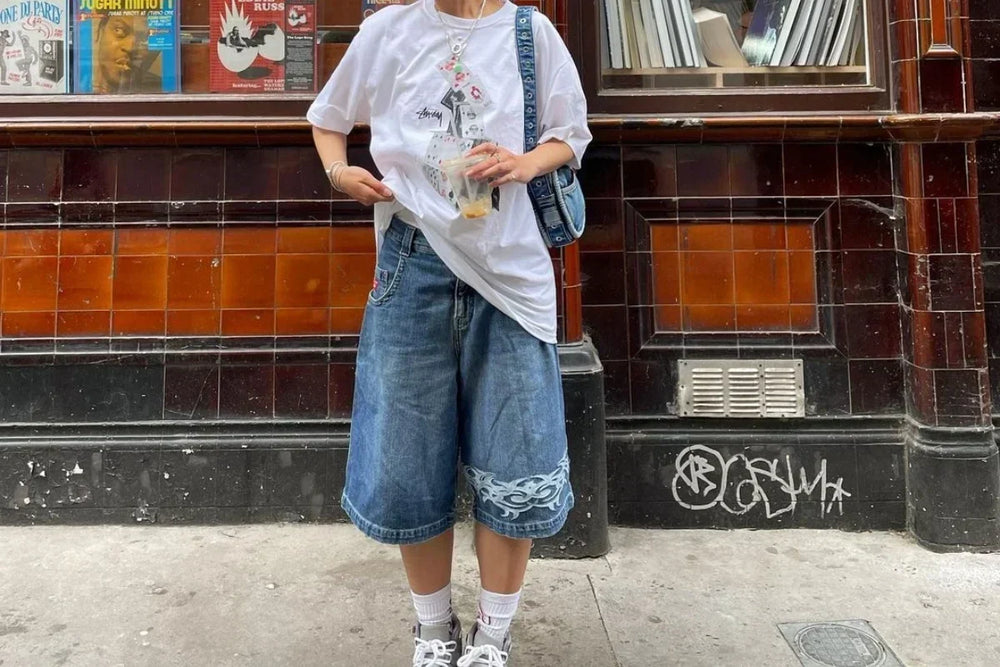 A streetwear photo of person baggy denim shorts and oversized tshirt.