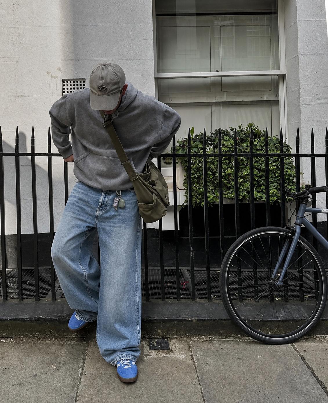 Man in baggy jeans outfit with bike.