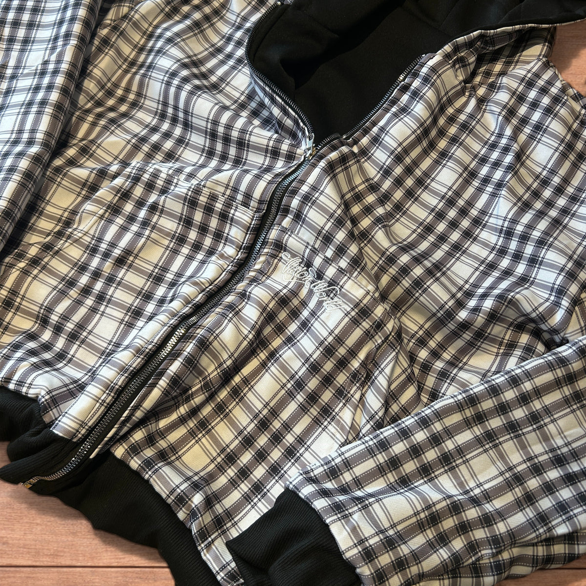 Close-up of a reversible black and grey checkered oversized zip-up hoodie