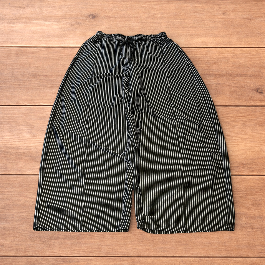 Super baggy dark grey wide leg Korean joggers with drawstring waist and pockets laid flat on wooden surface
