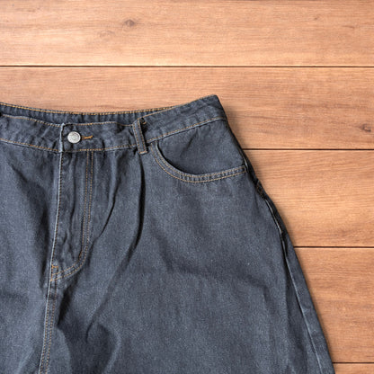 Baggy wide leg denim jorts in washed black with contrast stitching laid flat on wooden surface showing front and back views