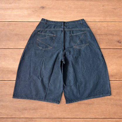 Baggy wide leg denim jorts in washed black with contrast stitching laid flat on wooden surface showing front and back views