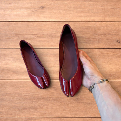 Red vintage style glossy faux leather tabi shoes with split toe and flat sole