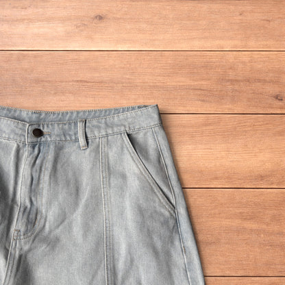 Light blue baggy wide leg vintage style denim jeans laid flat on wood surface showing front and back views