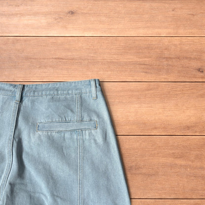 Light blue baggy wide leg vintage style denim jeans laid flat on wood surface showing front and back views
