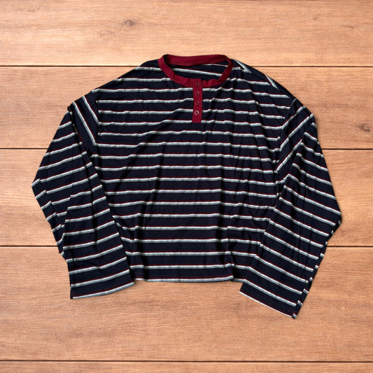 Navy navy blue striped henley long sleeve top with burgundy collar and button placket laid flat on wooden background