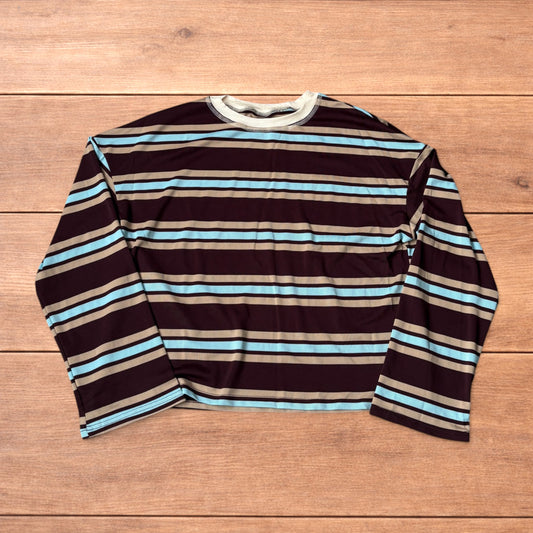Relaxed fit long sleeve striped t-shirt in brown, blue and beige laid flat on wooden surface