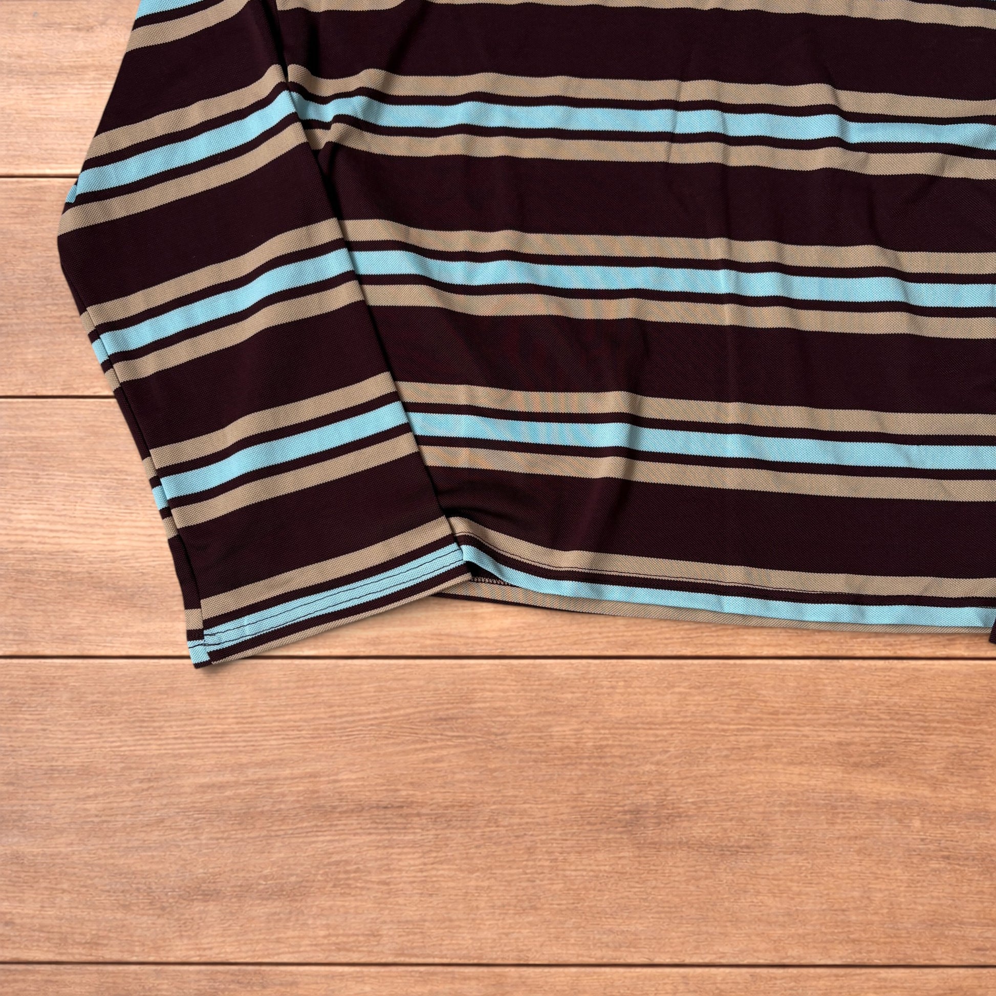 Relaxed fit long sleeve striped t-shirt in brown, blue and beige laid flat on wooden surface