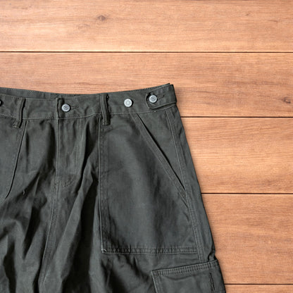 Vintage style baggy cargo shorts in khaki green laid flat on wooden surface showing front and back details.