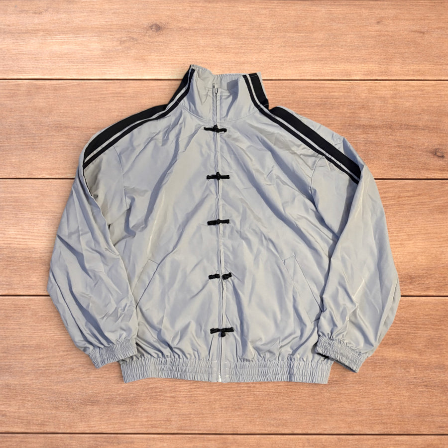 Light blue Japanese style zip up track jacket with black side stripes and toggle fasteners.