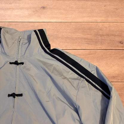 Light blue Japanese style zip up track jacket with black side stripes and toggle fasteners.