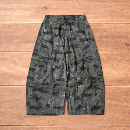 Baggy wide leg cargo trousers in army camo laid flat showing front, back and close-up details on wooden background.