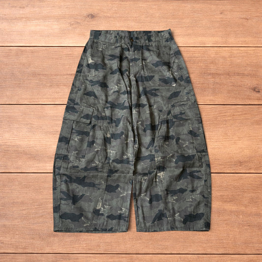Baggy wide leg cargo trousers in army camo laid flat showing front, back and close-up details on wooden background.