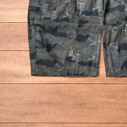 Baggy wide leg cargo trousers in army camo laid flat showing front, back and close-up details on wooden background.