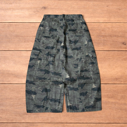 Baggy wide leg cargo trousers in army camo laid flat showing front, back and close-up details on wooden background.