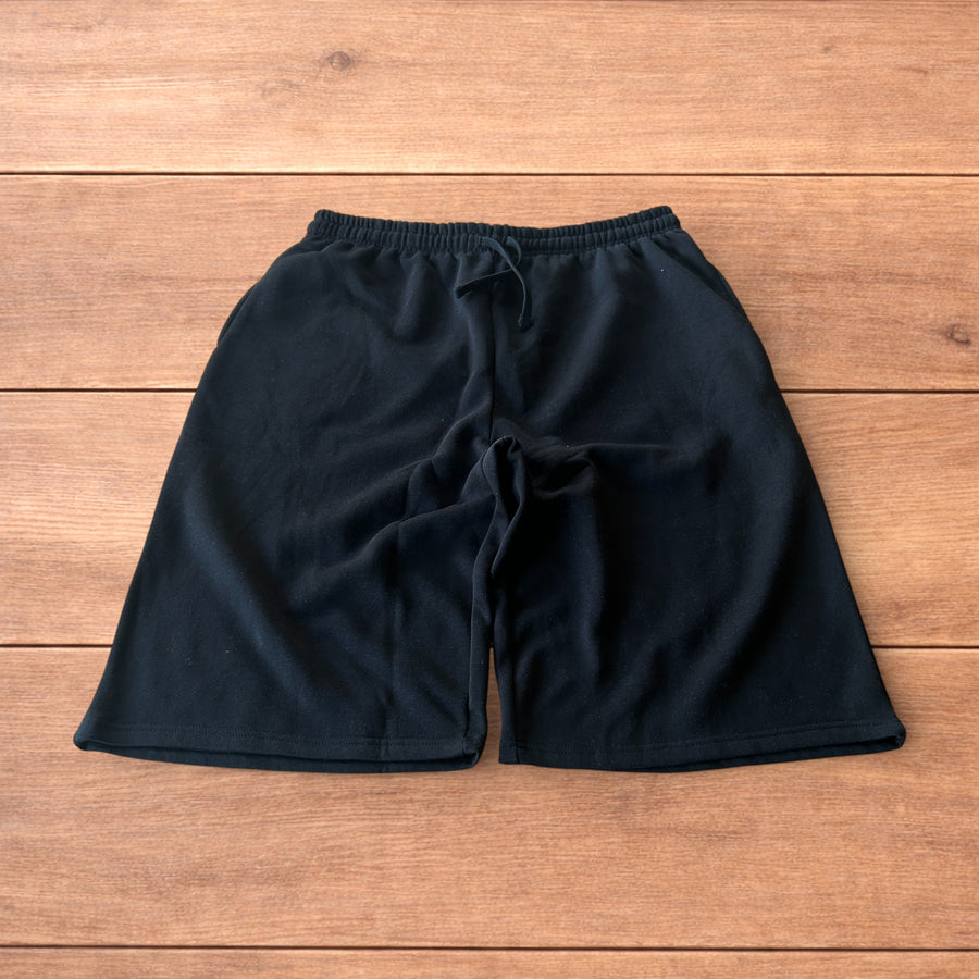 Lovely black super baggy wide leg long jersey shorts jorts laid flat on wooden floor