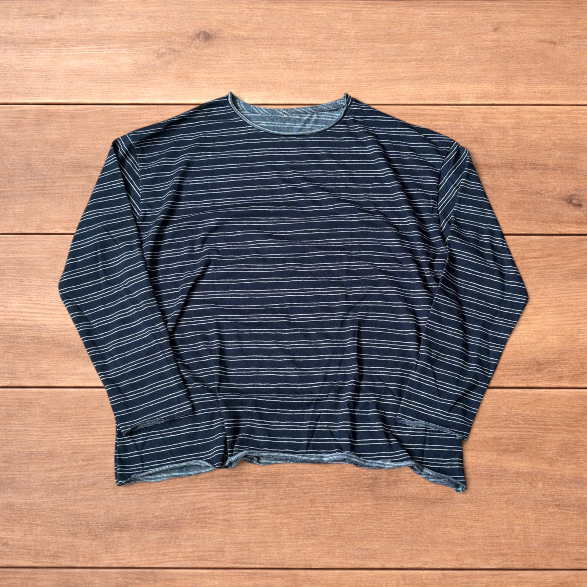 Relaxed fit navy and beige striped long sleeve top t-shirt laid flat on wooden surface showing front and back views.