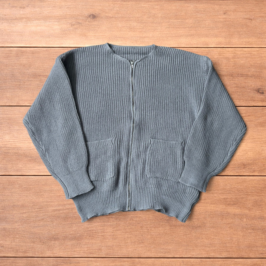 Grey Korean style knitted cardigan jumper with full zip and front pockets laid flat on wooden surface