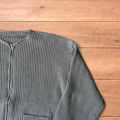 Grey Korean style knitted cardigan jumper with full zip and front pockets laid flat on wooden surface