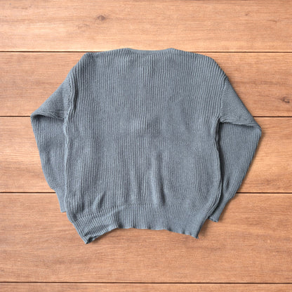 Grey Korean style knitted cardigan jumper with full zip and front pockets laid flat on wooden surface