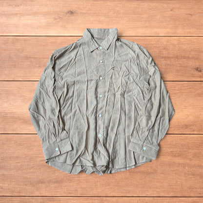 Vintage style camel beige button up long sleeve shirt with light blue buttons and chest pocket laid flat on wooden surface.