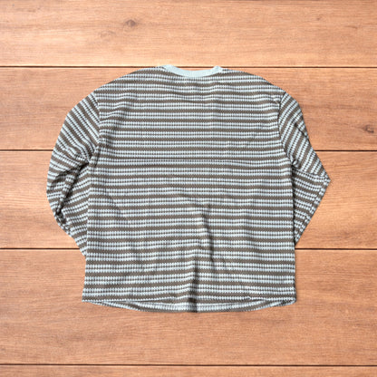 Relaxed fit striped knit top t-shirt in brown and cream laid flat on wooden floor.