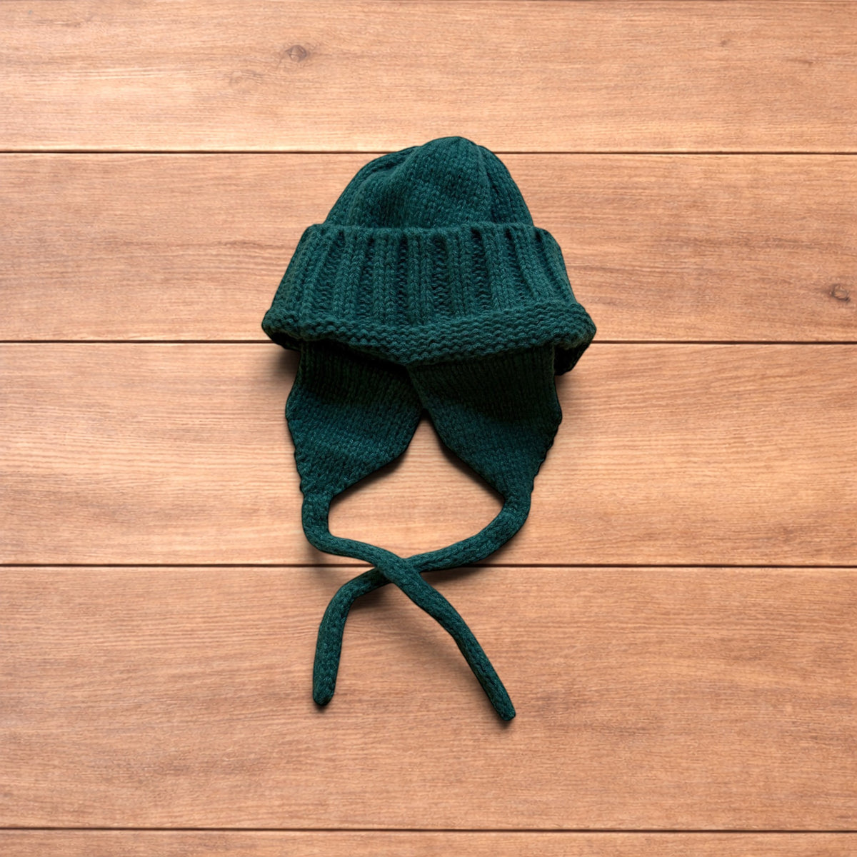 Vintage style dappy ear flap bobble hat in dark green.