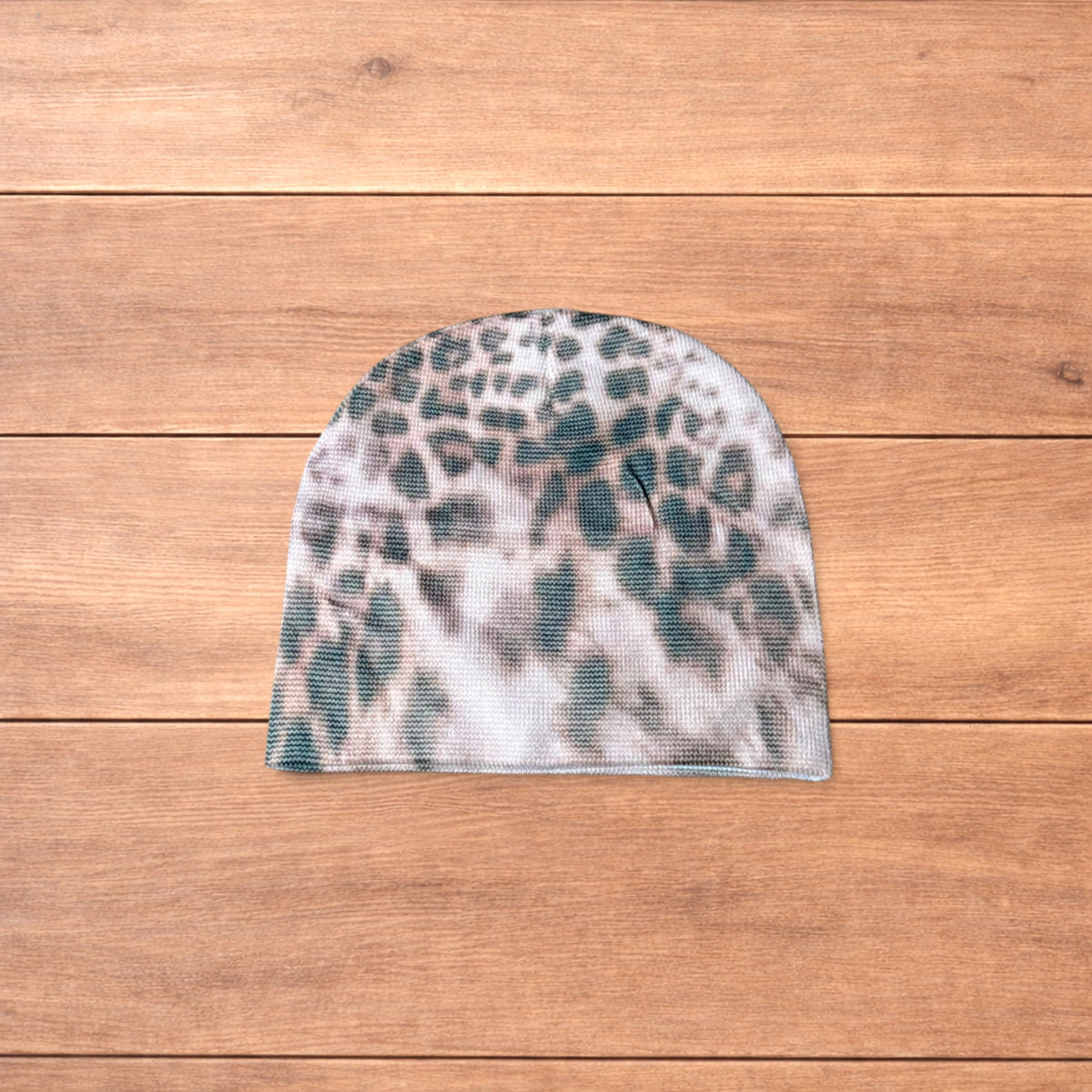 Japanese vintage style beige beanie hat with beige animal print pattern laid flat on wooden surface.