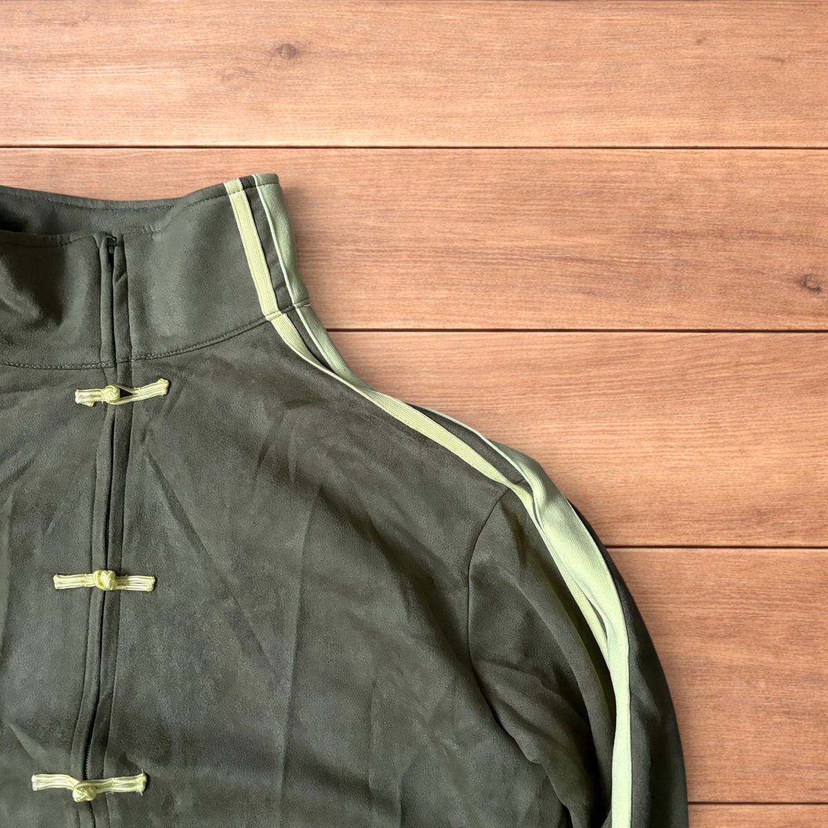 Japanese style zip up track jacket in khaki green with pale green stripes on sleeves and knotted loop front fastenings.