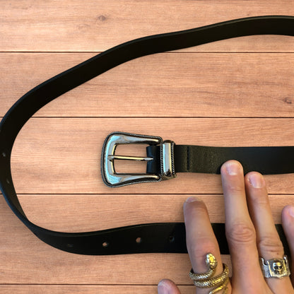 Vintage style faux leather western cowboy belt in black with silver trim.