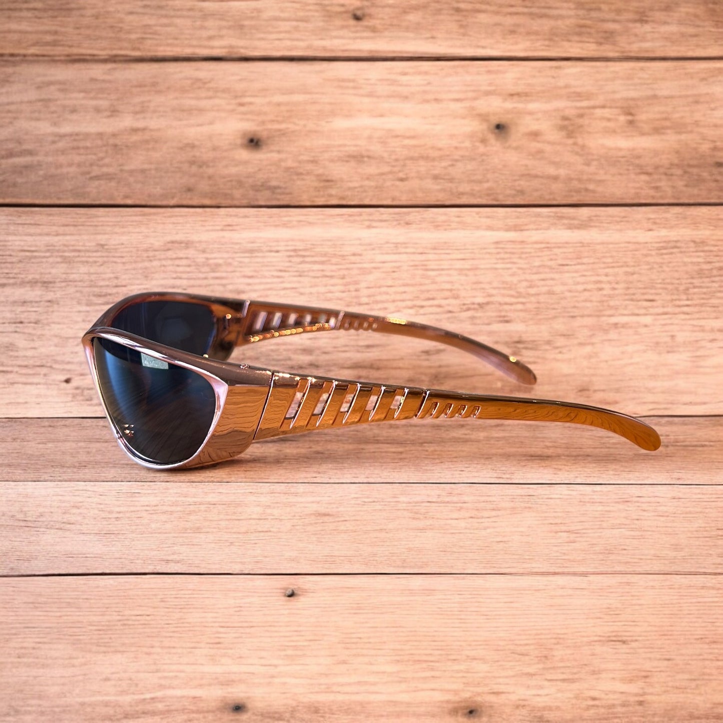 Cool wrap around sunglasses in rose gold frame with black lense. One size.