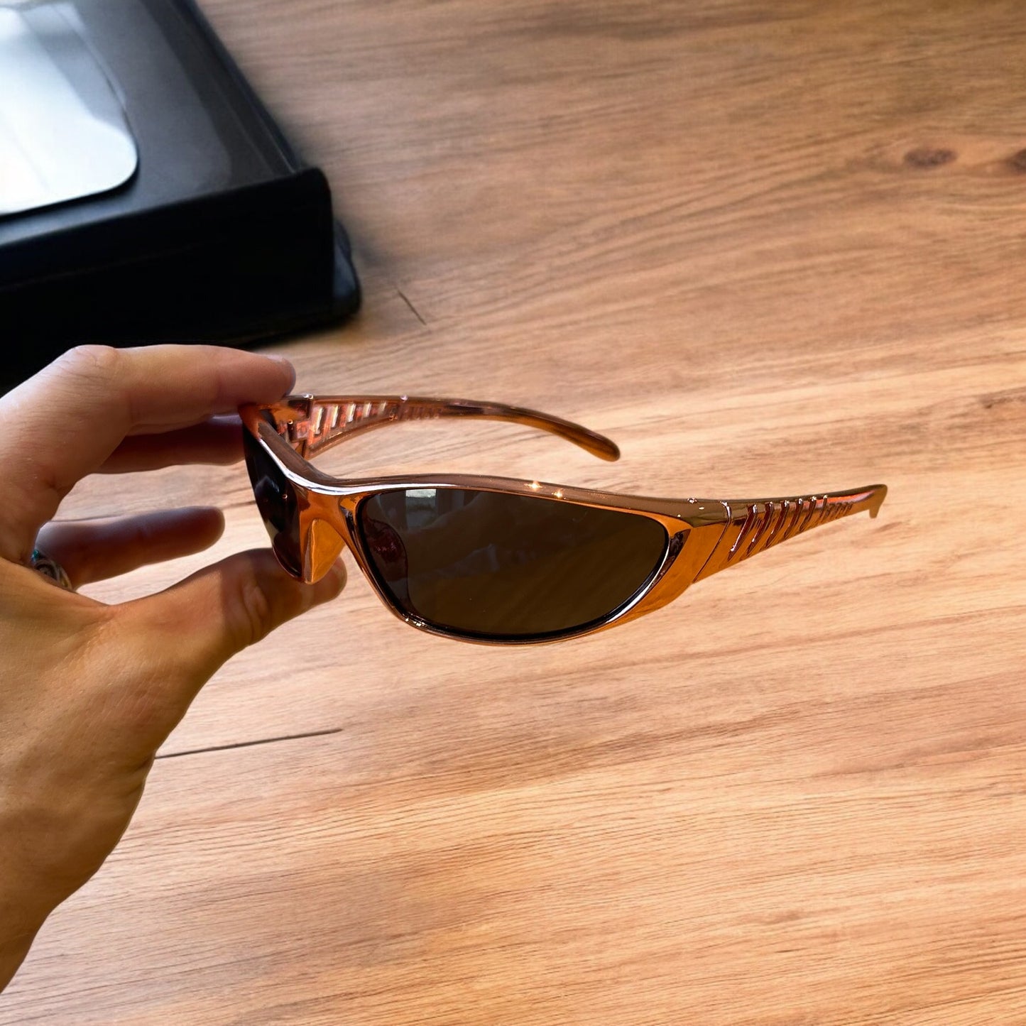 Cool wrap around sunglasses in rose gold frame with black lense. One size.