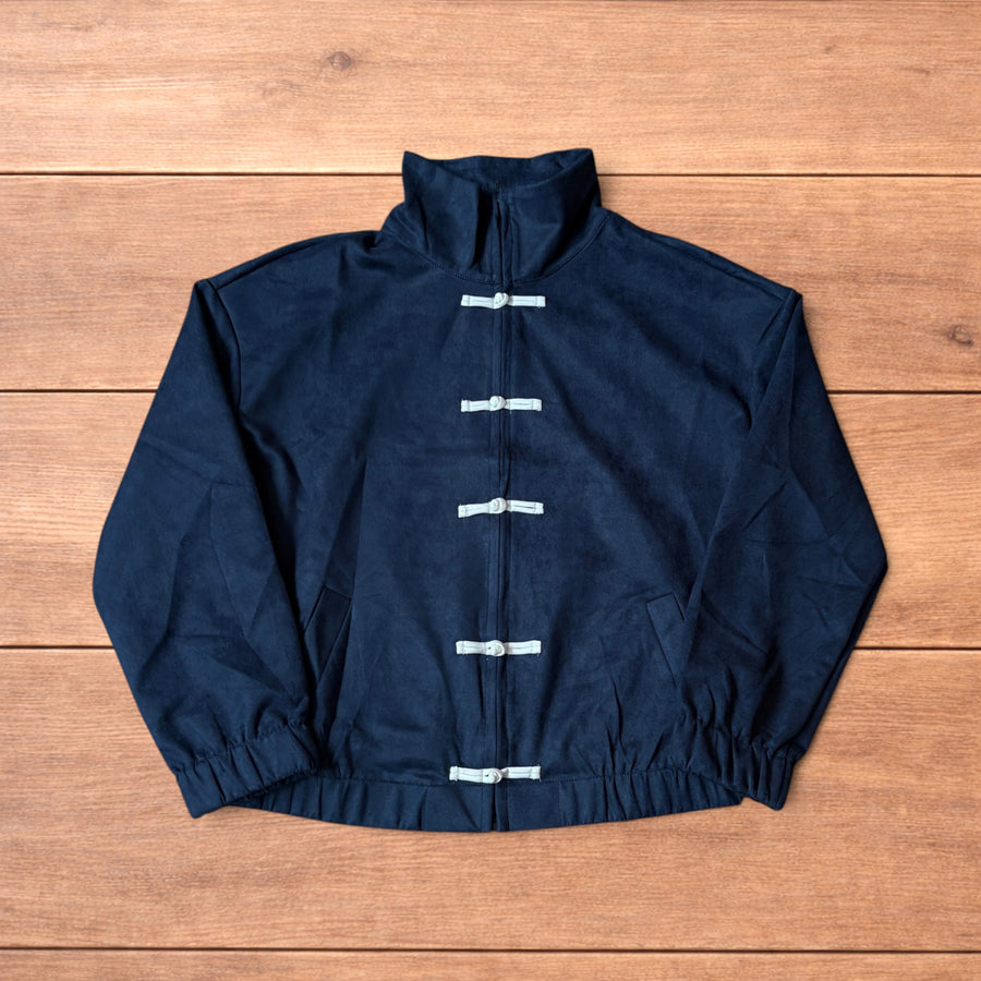 Japanese style navy blue zip up track jacket with white knotted fastenings on wooden background.