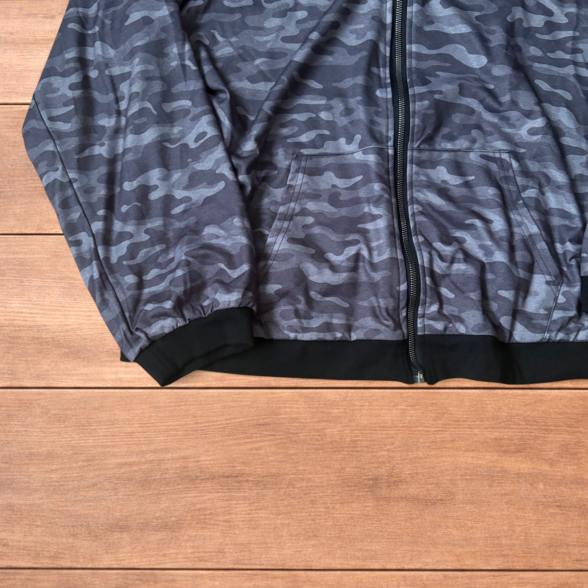 Oversized baggy reversible zip up hoodie jumper laid flat showing grey camo print and black hood lining