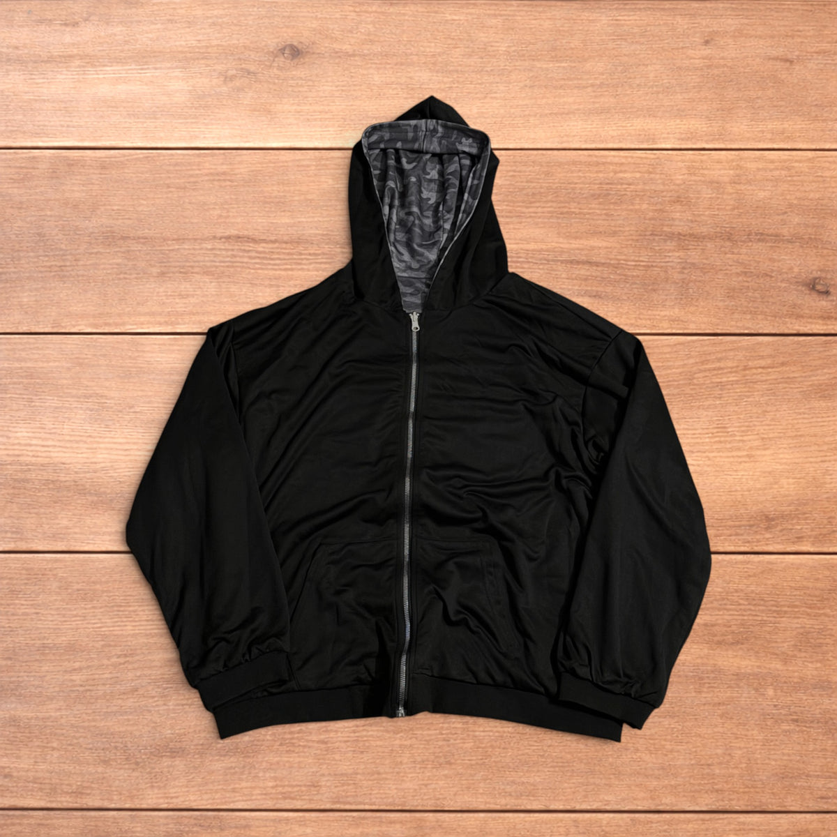 Oversized baggy reversible zip up hoodie jumper laid flat showing grey camo print and black hood lining