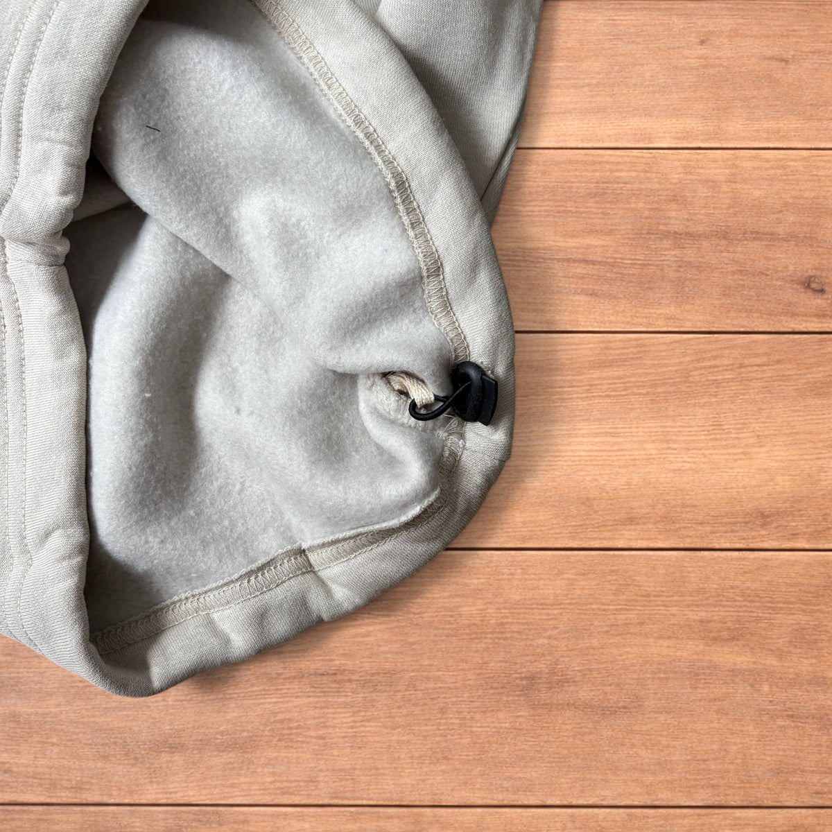 Pale grey baggy joggers laid flat showing elastic waistband with drawstring and wide leg cut.