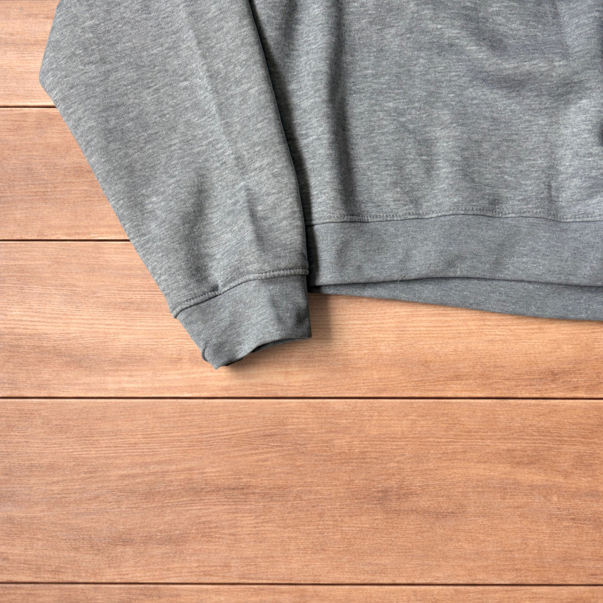 Grey baggy gym sweatshirt laid flat showing front, raglan sleeves, ribbed neckline, cuffs, and hem.