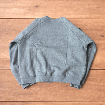 Grey baggy gym sweatshirt laid flat showing front, raglan sleeves, ribbed neckline, cuffs, and hem.