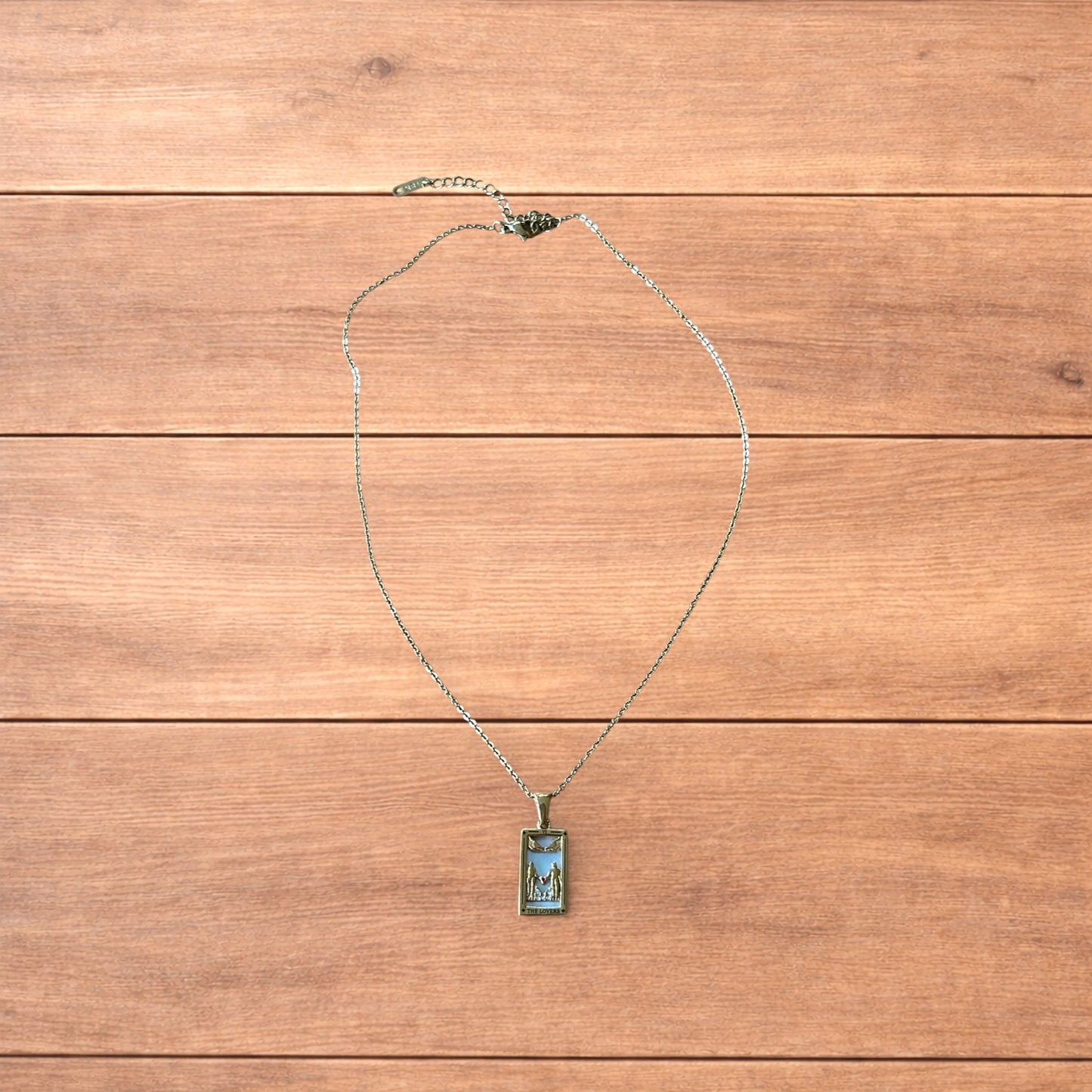 Gold stainless steel pendant necklace with The Lovers tarot card design featuring a couple holding hands and a heart detail.