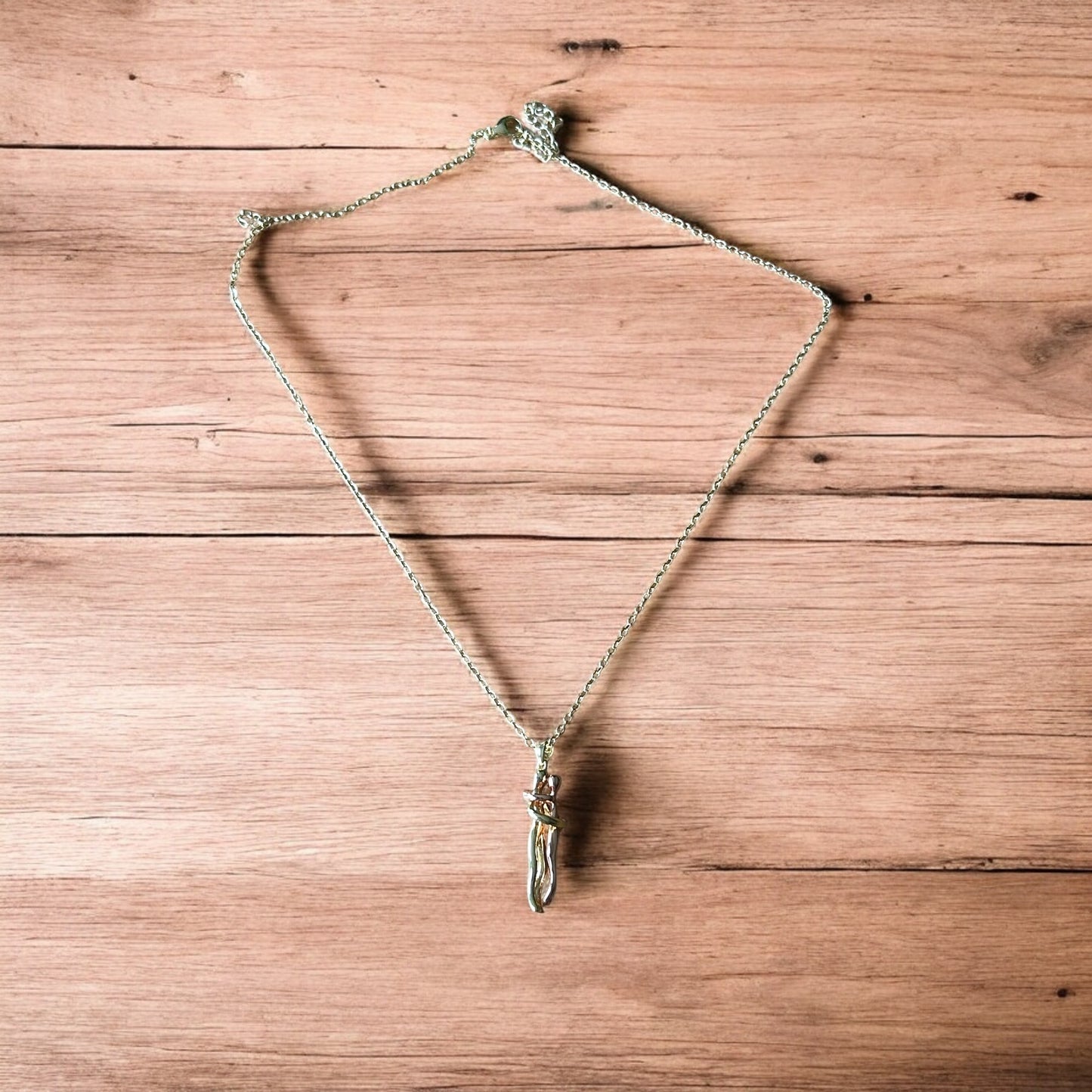 Lovely stainless steel necklace of couple figure silhouettes dancing in gold/rose gold.