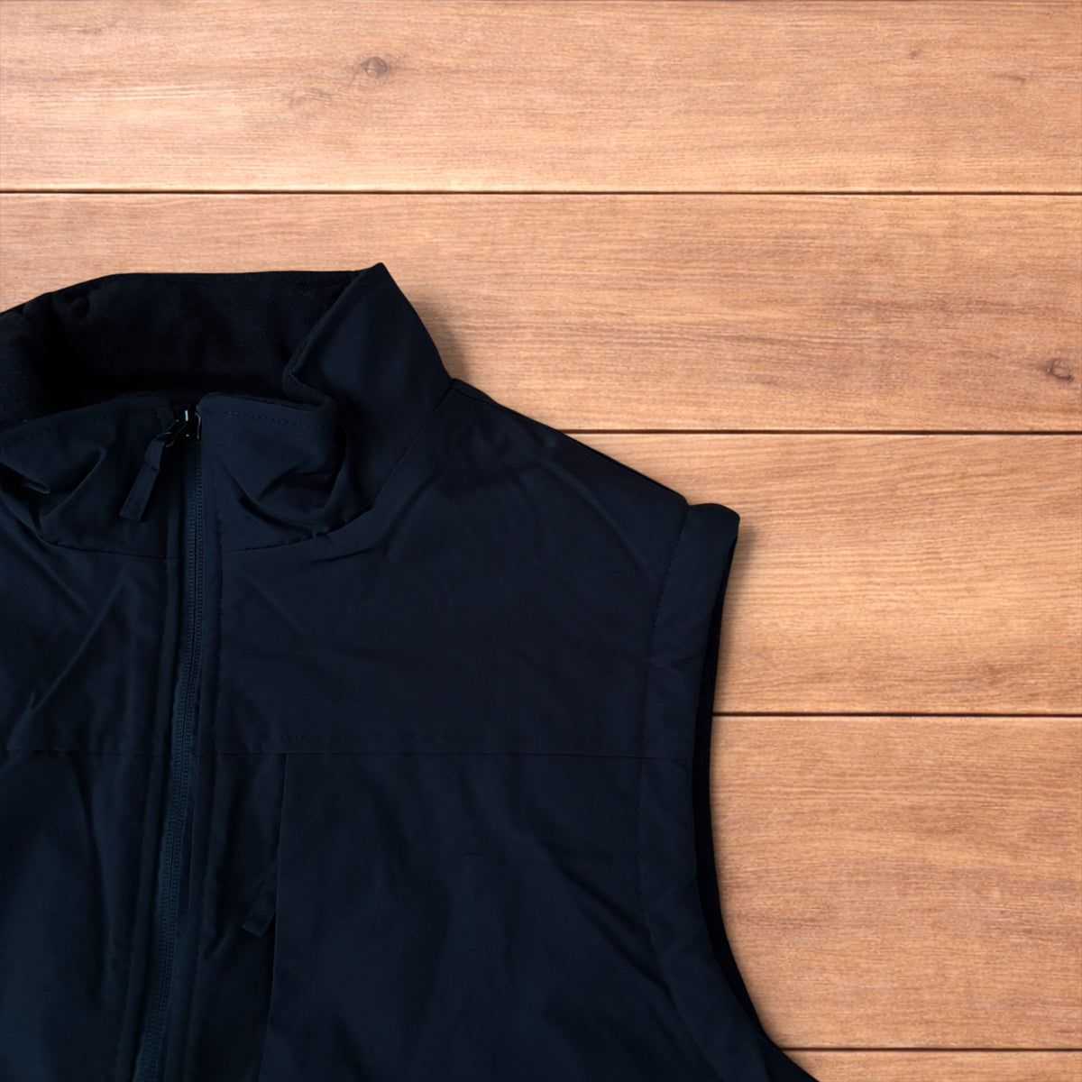 Reversible black utility gilet with high neck, full zip and pockets on both fleece and nylon sides.