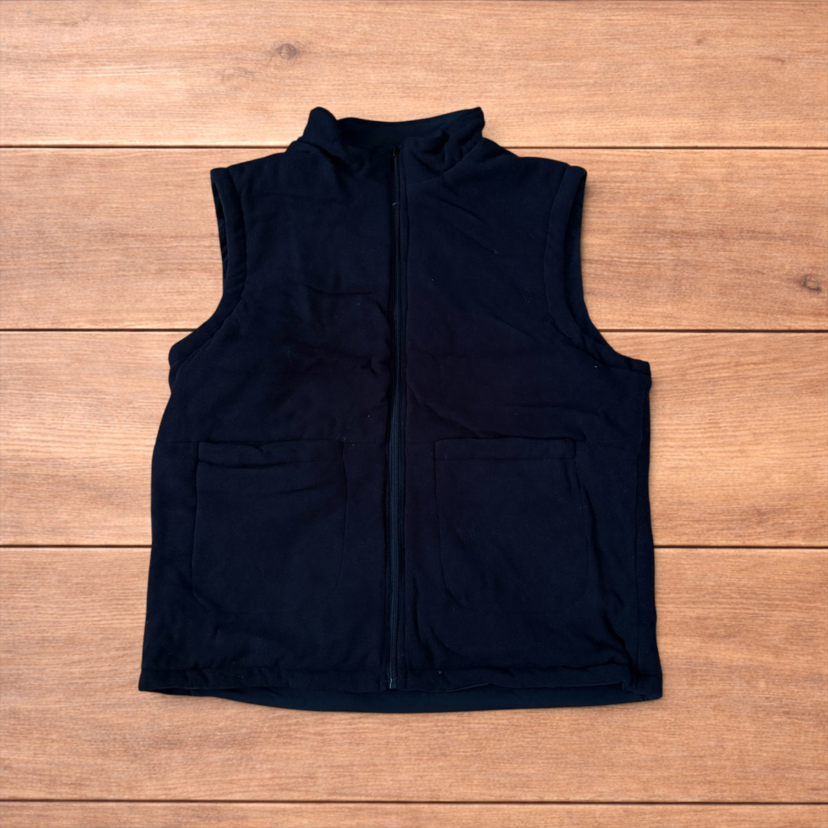 Reversible black utility gilet with high neck, full zip and pockets on both fleece and nylon sides.