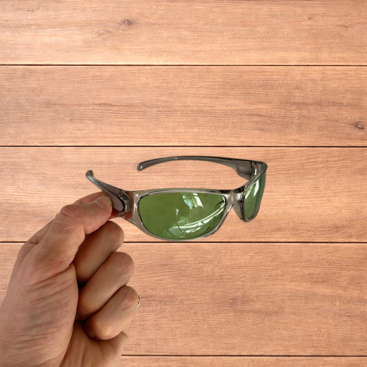 Silver wraparound sunglasses with green lenses