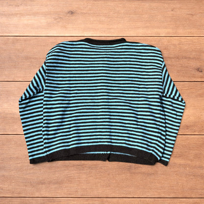 Turquoise and black striped vintage knitted cardigan jumper with button-up front laid flat on wooden surface.