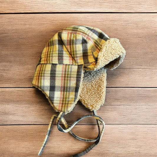 Trapper ear flap winter hat in checkered beige colour way. One size.