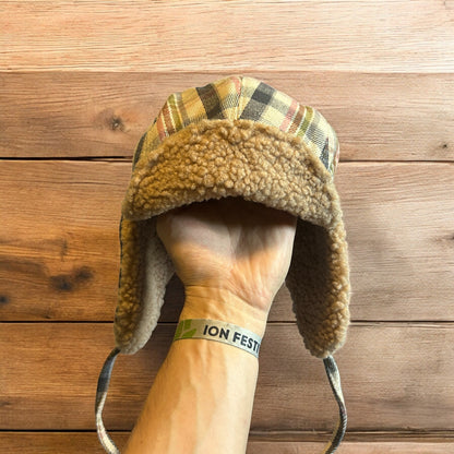 Trapper ear flap winter hat in checkered beige colour way. One size.
